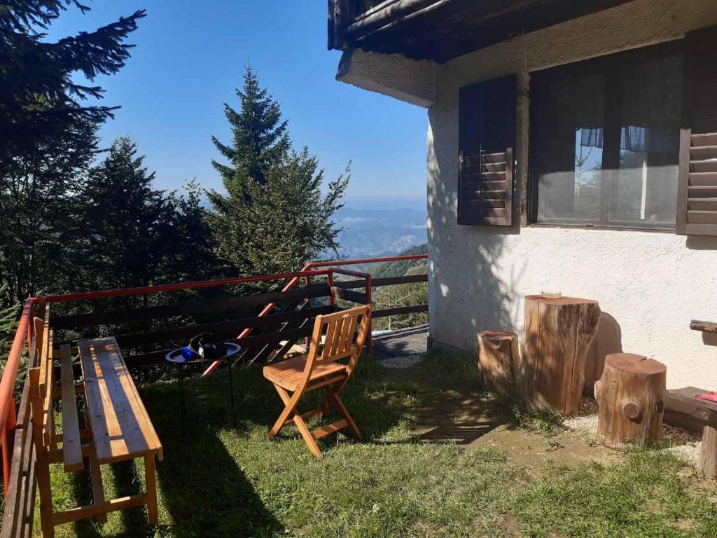 una casa con una mesa, un banco y un árbol en Weekendica, en Kopaonik
