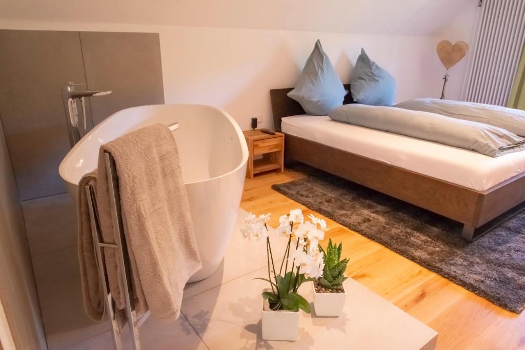 a bathroom with a bath tub next to a bed at Haus Nilson in Gengenbach