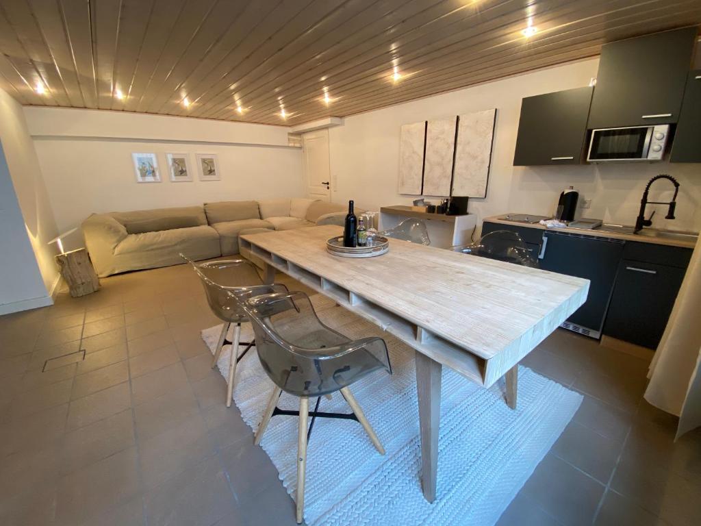 eine Küche und ein Wohnzimmer mit einem Holztisch und Stühlen in der Unterkunft basement 77 in Tönisvorst