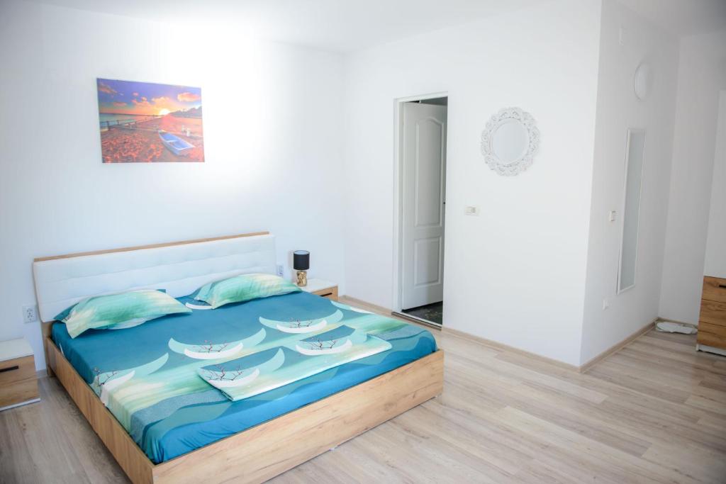 um quarto com uma cama com um quadro na parede em Vila Axelandra em Eforie Nord