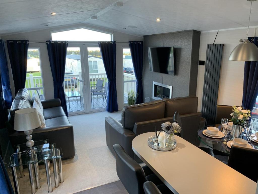 sala de estar con sofás, mesa y sillas en Lola Lodge - Luxury Hot Tub Retreat en Newton on the Moor