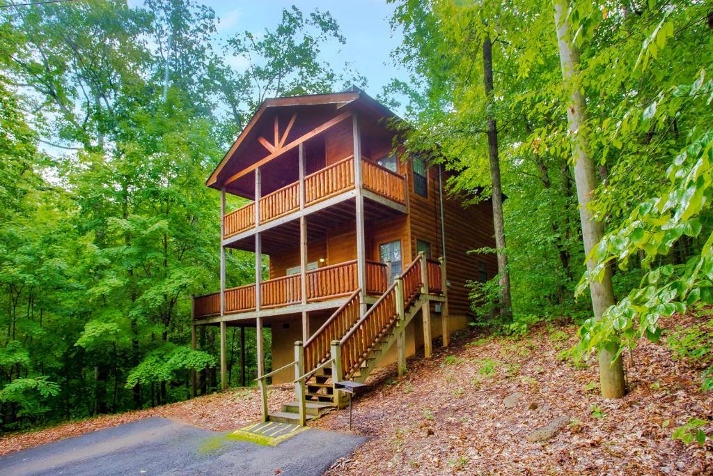 a tree house in the woods with a staircase at Suite Sensations in Pigeon Forge