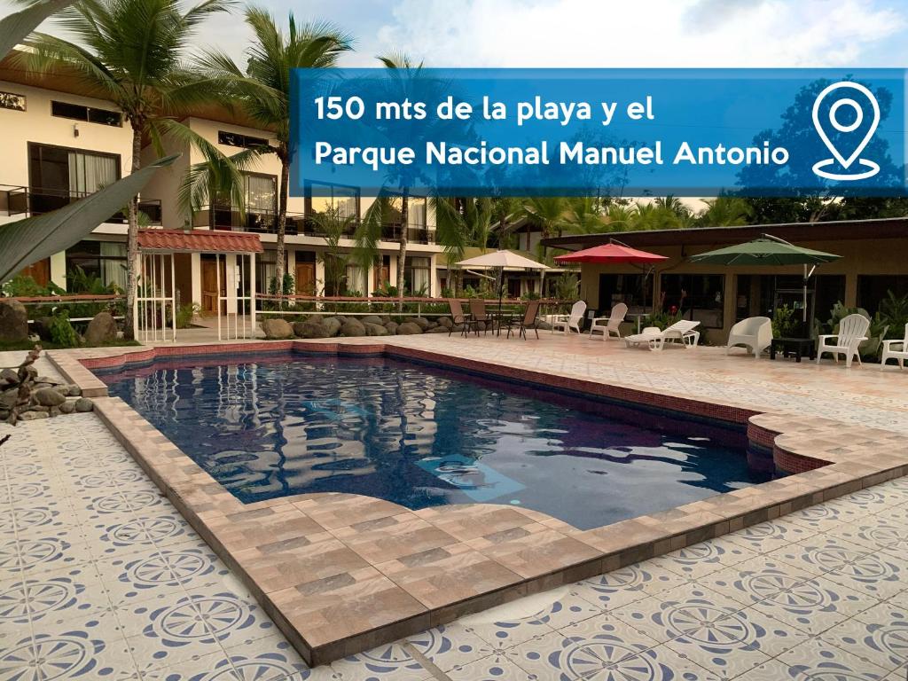 a pool at a hotel with a sign that reads miles die la play y at Hotel Manuel Antonio Park in Manuel Antonio