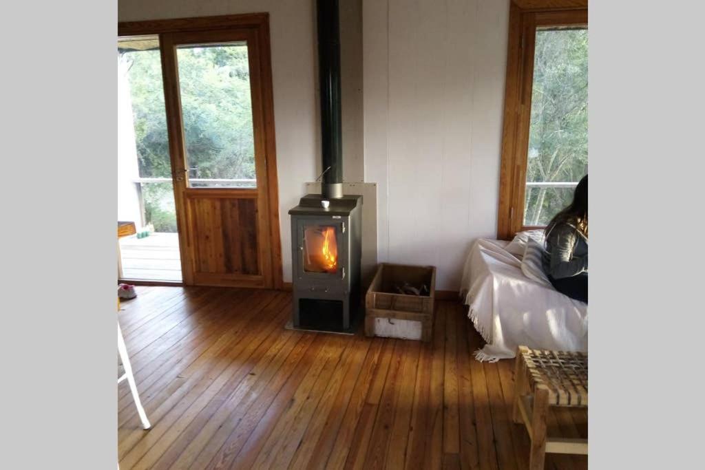 una sala de estar con estufa de leña. en Rinconcito - Casa de descanso y río en Punta Gorda, Uruguay, en Nueva Palmira