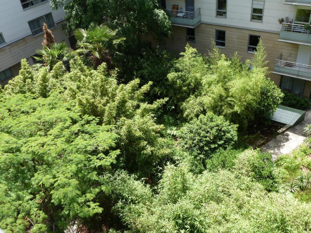 a bunch of trees and bushes in front of a building at Appartement Alésia - Plaisance in Paris