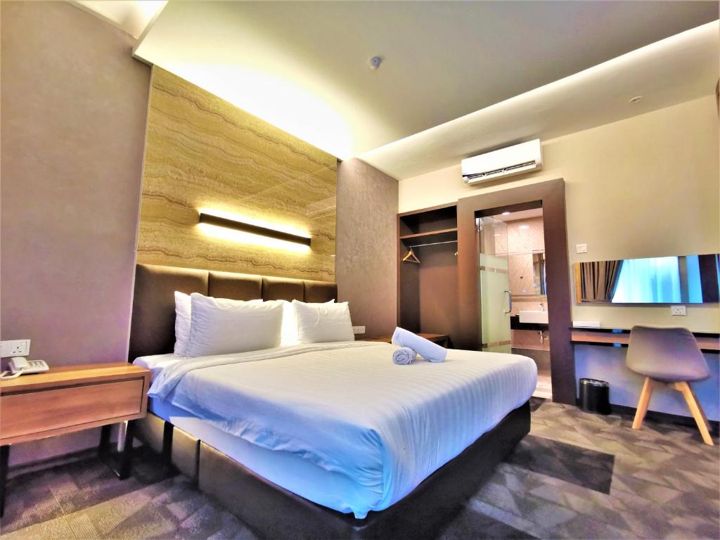 a hotel room with a large bed and a desk at Prestigo Hotel - Johor Bharu in Johor Bahru