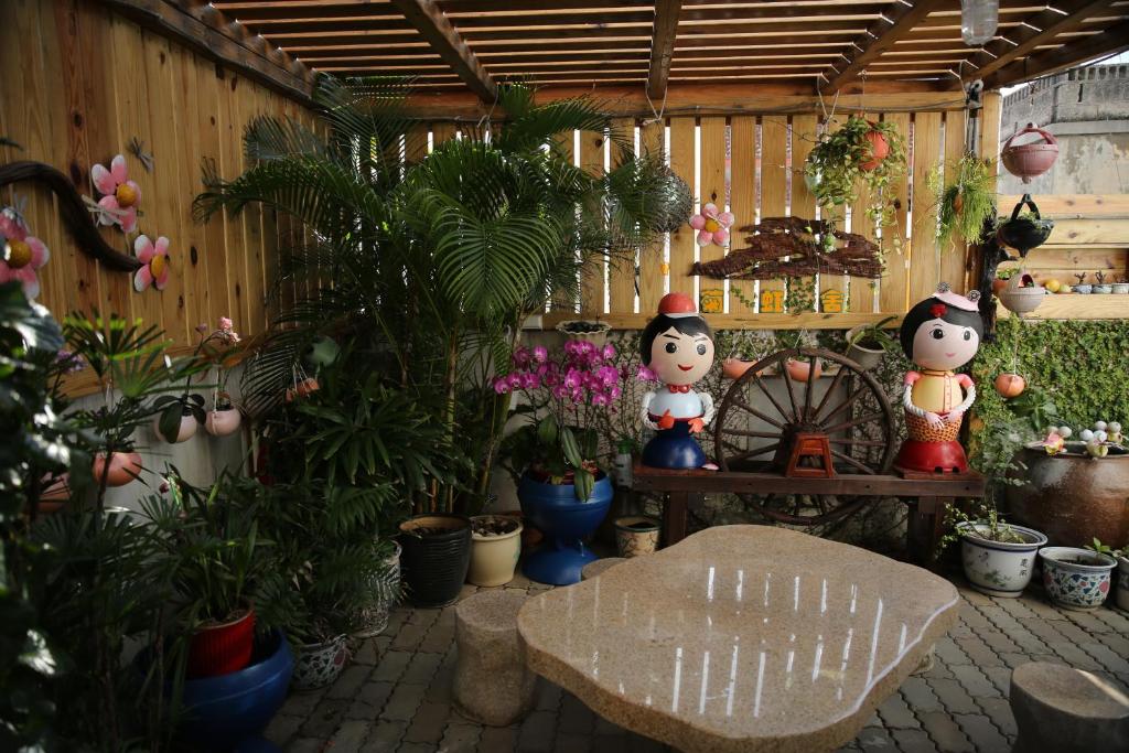 a garden with two hello kitty figurines and plants at G Home Sir B&B in Magong
