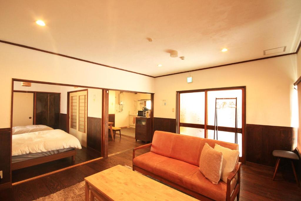 um quarto com uma cama e um sofá num quarto em kODATEL コダテル函館ウエストサイド em Hakodate