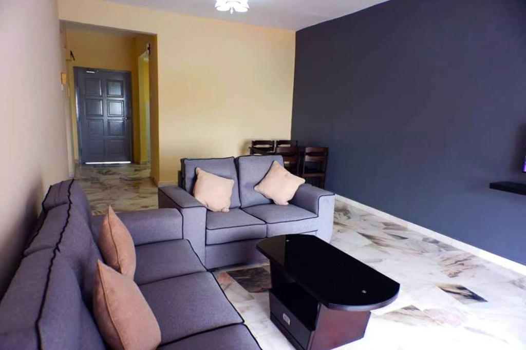 un soggiorno con divano e tavolo di BayView Villa Condominium Apartment A a Kampong Baharu