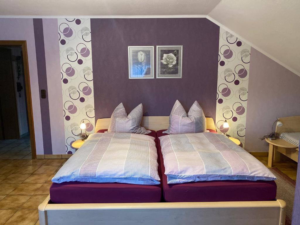 sypialnia z 2 łóżkami i fioletowymi ścianami w obiekcie Pension Görgen w mieście Herresbach