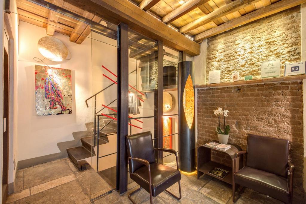 a room with two chairs and a brick wall at Residenza Torre Colonna in Rome