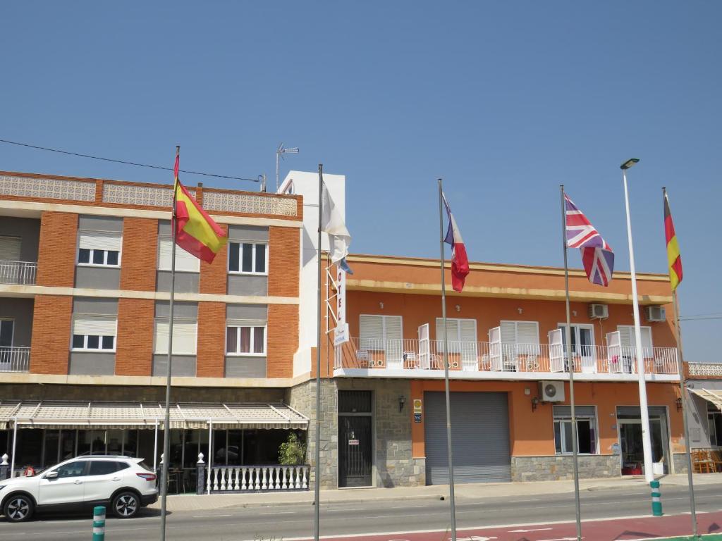 a building with flags in front of it at Hotel Montemar in La Marina