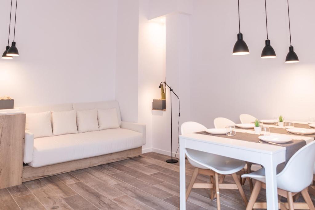 - un salon avec un canapé blanc, une table et des chaises dans l'établissement NUEVO luminoso y con terrazas junto a la playa, à Sant Feliu de Guíxols