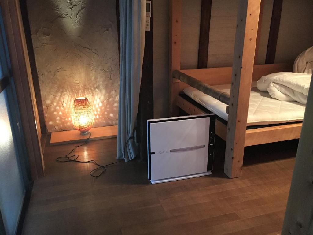 una TV seduta sul pavimento in una camera con letti a castello di Guest House Oku a Nara