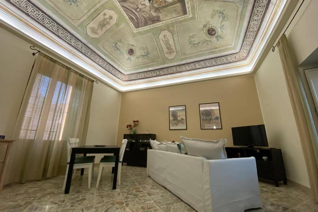 a living room with a ceiling with a table and a couch at Le quattro stagioni - The Four Seasons in San Gregorio di Catania
