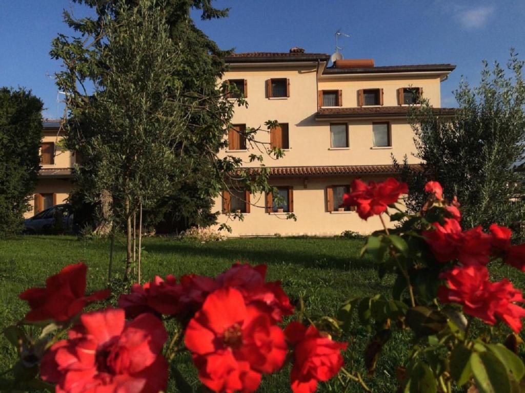 a building with red flowers in front of it at B&B Mirò in Pieve di Soligo