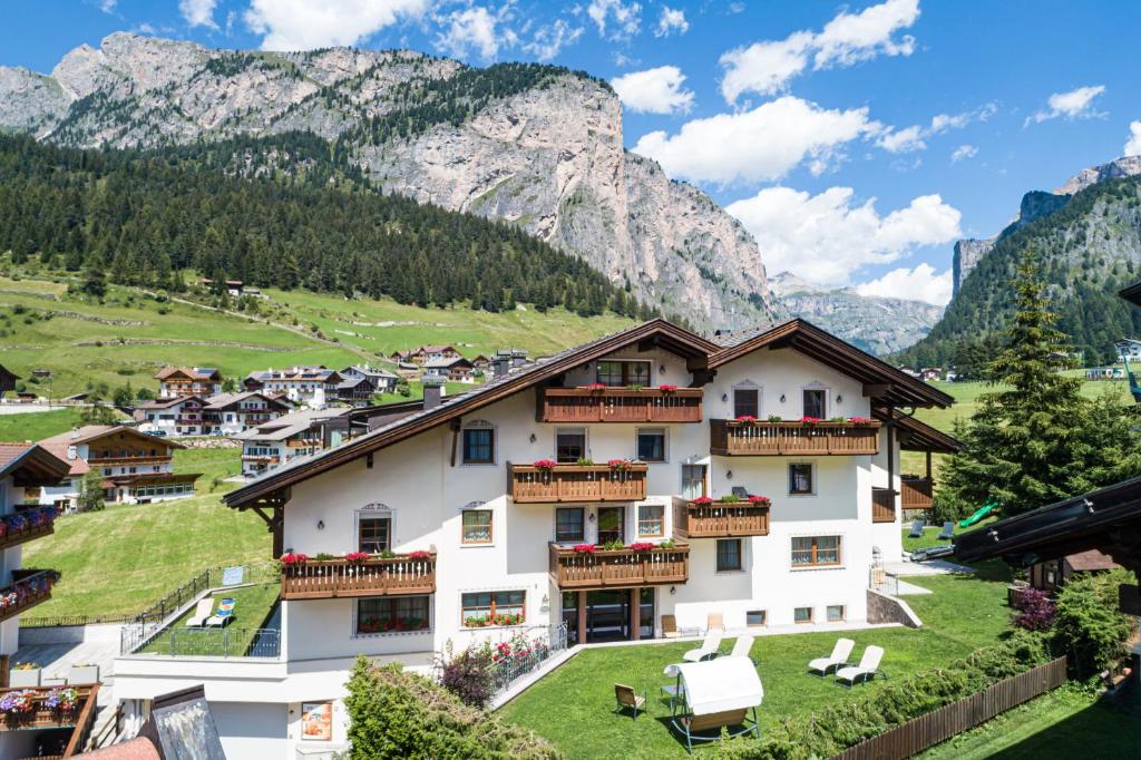 a hotel in the mountains with mountains in the background at Residence Cesa Rives in Selva di Val Gardena