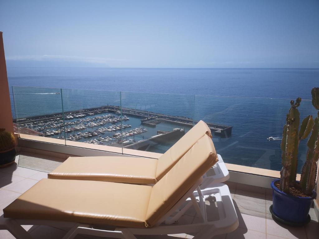 a chair in a room with a view of the ocean at Luxury Apt. with Stunning Sea View in Acantilado de los Gigantes