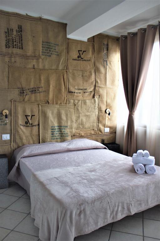 una camera da letto con un letto grande con asciugamani sopra di 1928 Guest House a Pogno