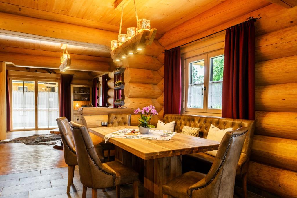 a dining room with a wooden table and chairs at Alpenchalet St.Ulrich in Krün