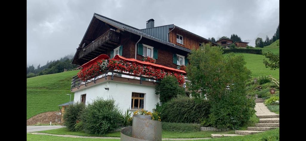 una casa su una collina con dei fiori sopra di Schäfer Zita a Fontanella