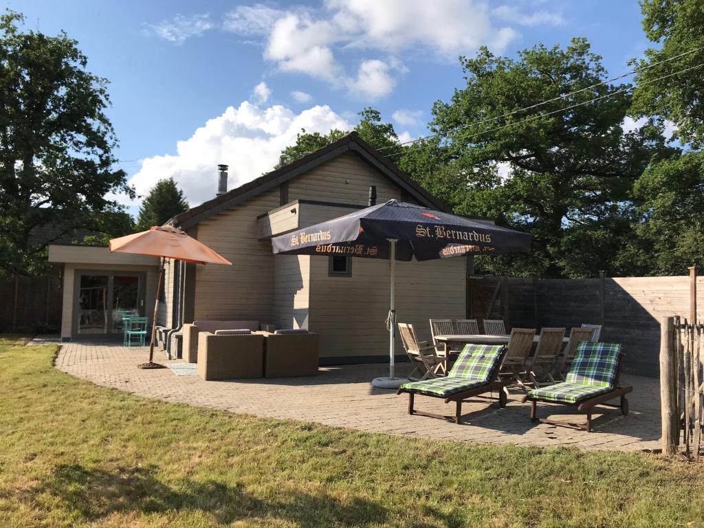 eine Terrasse mit 2 Stühlen und einem Sonnenschirm in der Unterkunft La Brindille in Durbuy