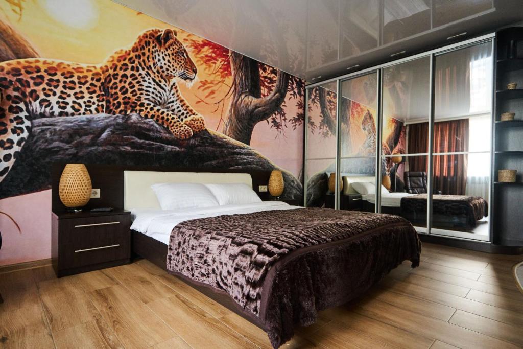 1 dormitorio con 1 cama y un mural de tigre en la pared en Apartment - Sobornaya Street, en Kremenchuk