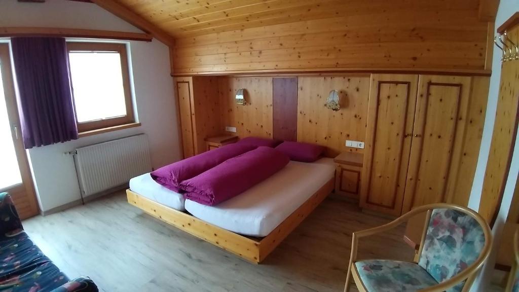 a bedroom with a bed in a wooden room at virgen-urlaub in Virgen