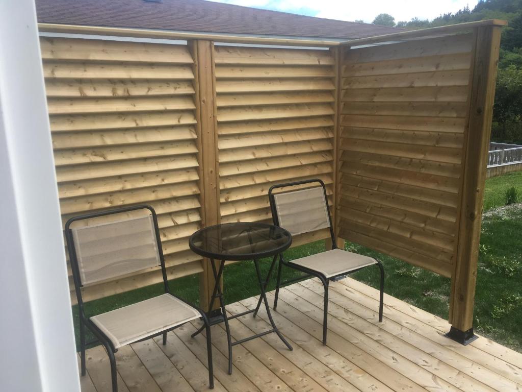 two chairs and a table on a deck at Quidi Vidi Retreat 3 in St. John's