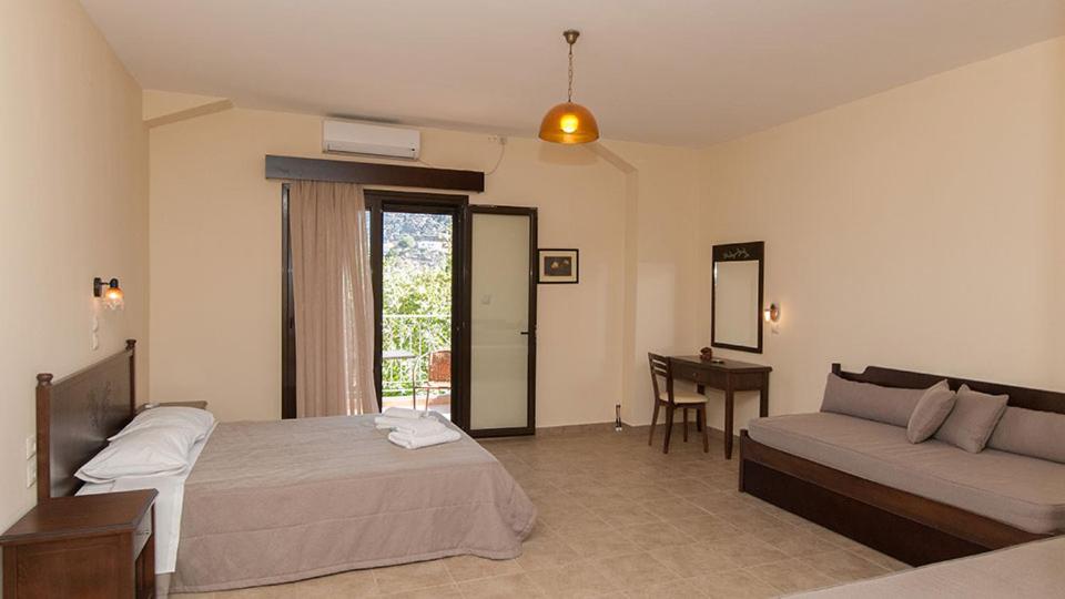 a bedroom with a bed and a couch and a table at Anopoli Rooms in Sinoikismós Kámbos