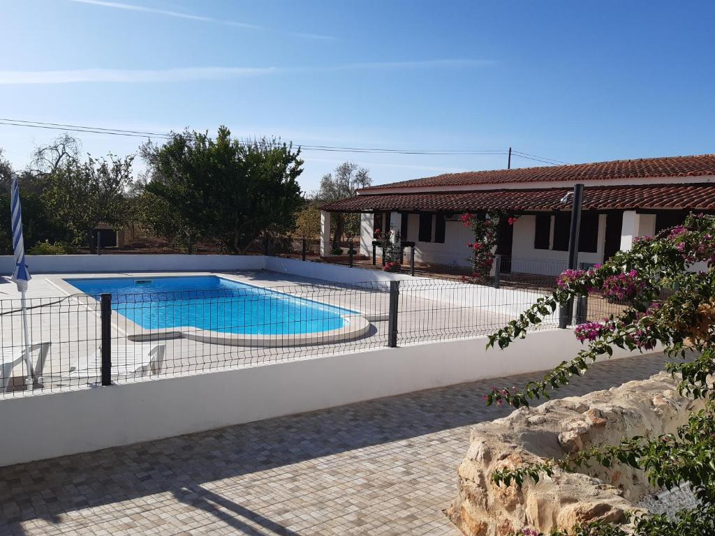 a house with a swimming pool in a yard at Quinta Cosy in Paderne