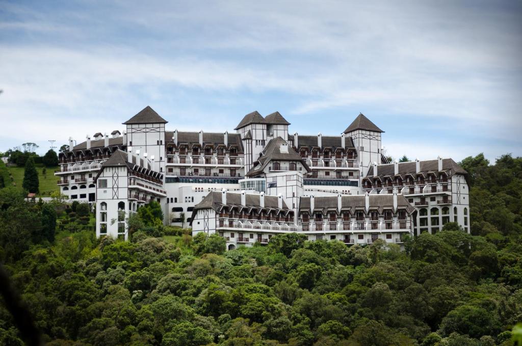 a large white building on top of a hill at Hotel Home Green Home in Campos do Jordão