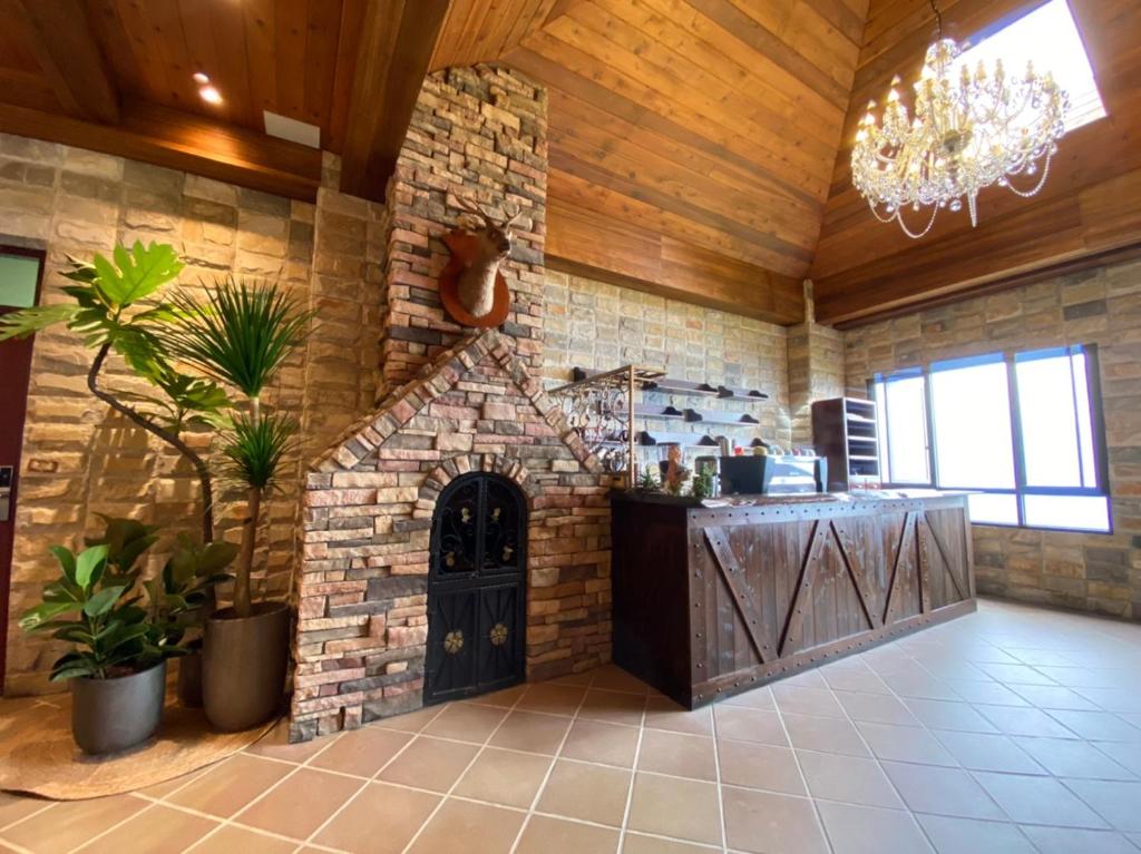 a large kitchen with a stone fireplace in a room at Cingjing Florence Resort Villa in Ren&#39;ai