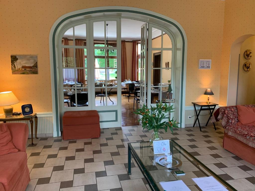 a living room with an archway and a couch and a table at L'Étape Fagnarde - Bed, Breakfast & Sauna in Spa