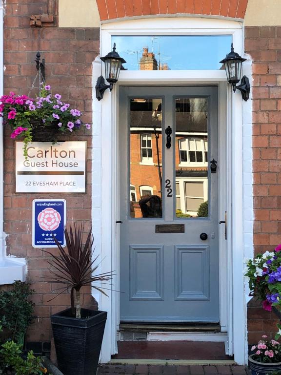 uma porta da frente de uma casa com uma porta azul em Carlton Guest House em Stratford-upon-Avon