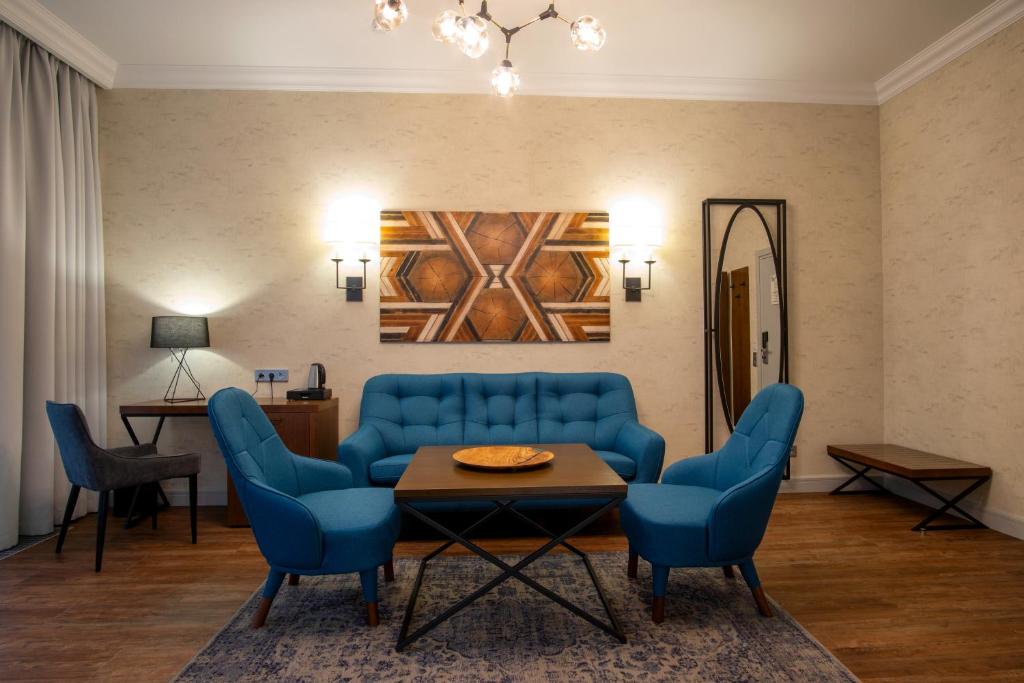 a living room with blue chairs and a table at Botanica Hotel in Arkhangelsk