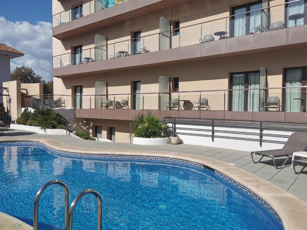 a swimming pool in front of a building at Petit Palau - Adults Only in Blanes