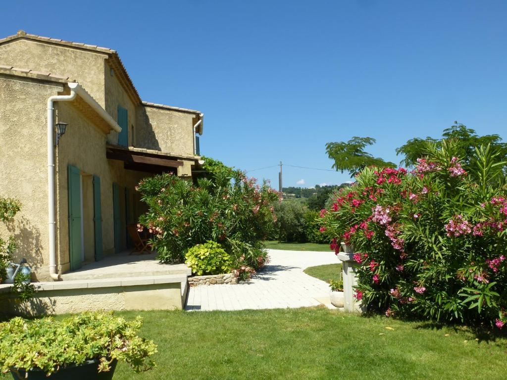 a garden with pink flowers and a building at CHAMBRES D&#39;HÔTES CLIMATISÉES avec CUISINE d&#39;ÉTÉ &quot;VILLA GOUR du PEYROL&quot; in Buisson