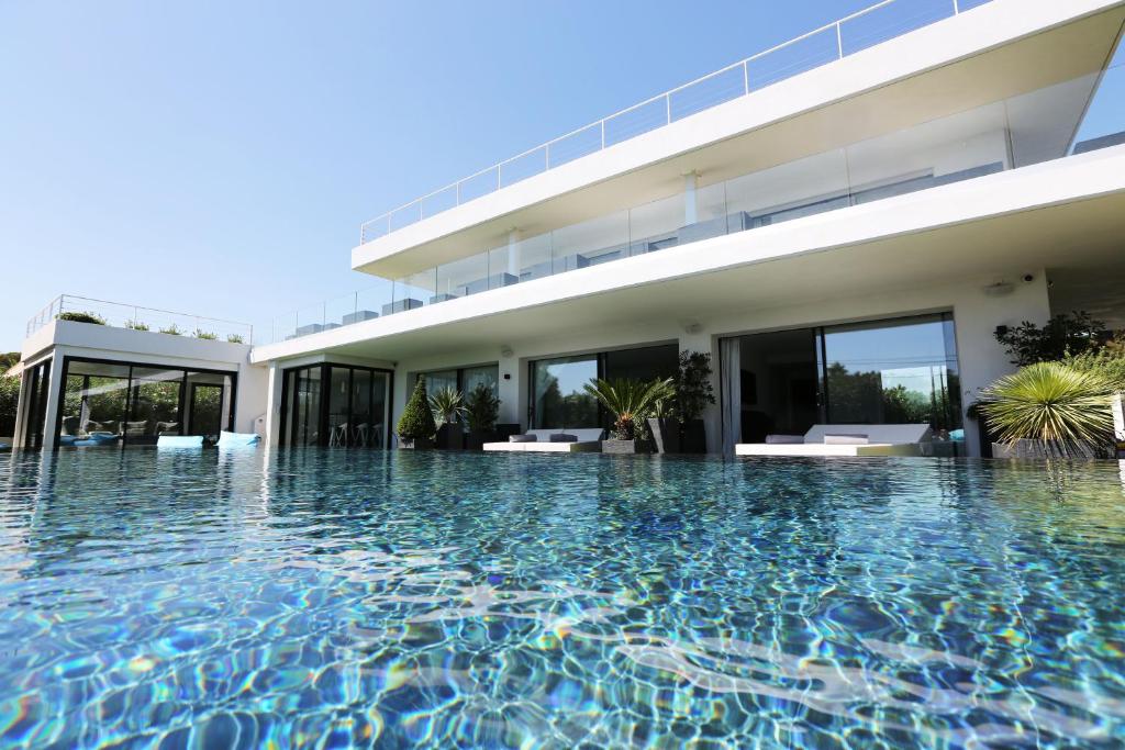 - une piscine en face d'une maison dans l'établissement VILLA MIAMI, aux Issambres