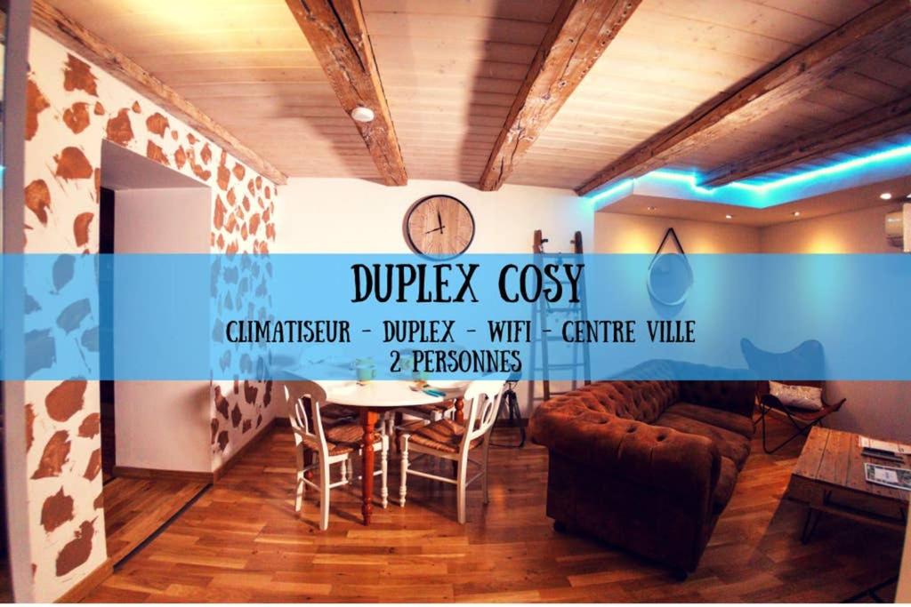 Cette chambre comprend une table avec des chaises et un canapé. dans l'établissement DUPLEX COSY Superdole - Classé 3 étoiles, à Dole