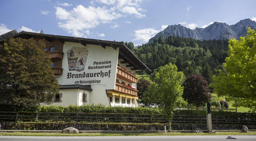 a hotel with a sign on the side of it at Aparthotel Brandauerhof in Walchsee