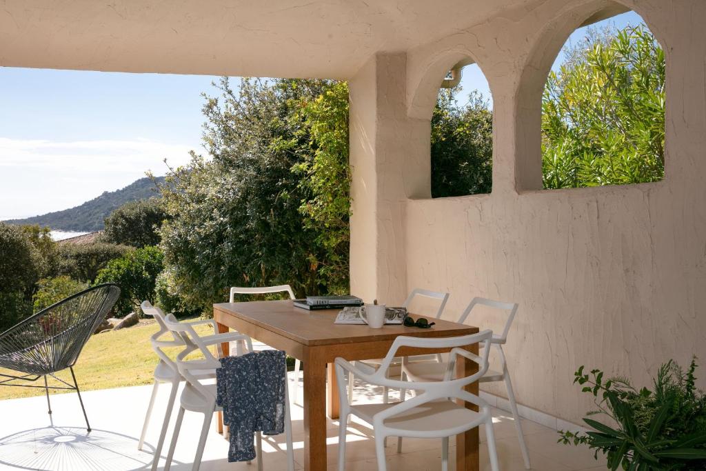a wooden table and chairs on a patio at Domaine Santa Giulia Palace in Porto-Vecchio