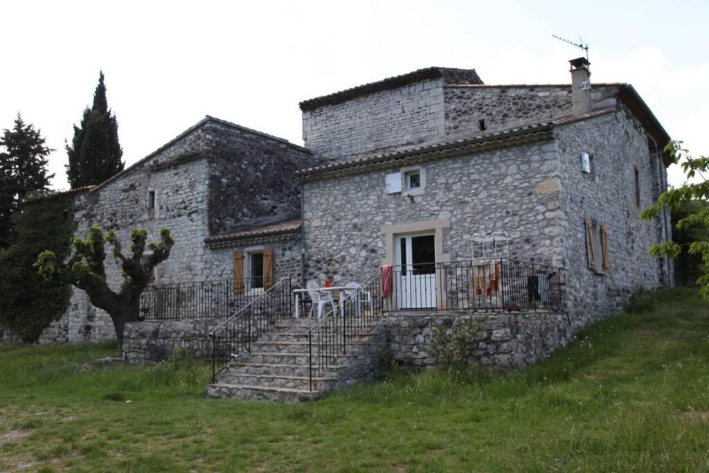 an old stone house with stairs and a table on it at Escoutay dans bastide Médiévale in Saint-Thomé