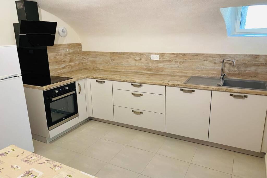 a kitchen with white cabinets and a sink at Escoutay dans bastide Médiévale in Saint-Thomé