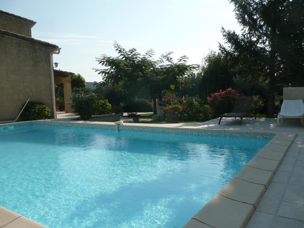 - une piscine d'eau bleue dans la cour dans l'établissement CHAMBRES D'HÔTES CLIMATISÉES avec CUISINE d'ÉTÉ "VILLA GOUR du PEYROL", à Buisson