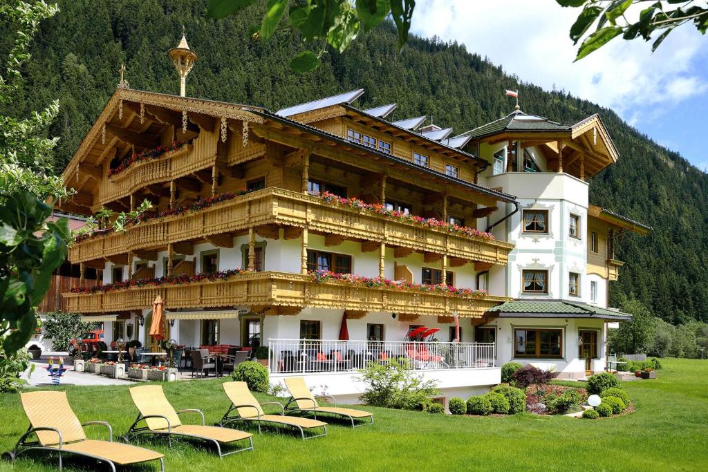um grande edifício com cadeiras em frente em Ferienhof Oblasser em Mayrhofen