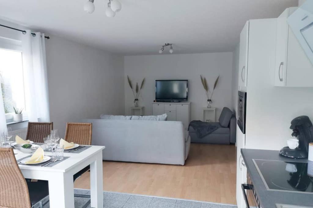 a living room with a white table and a white couch at Ferienwohnung Rhode in Rielasingen-Worblingen