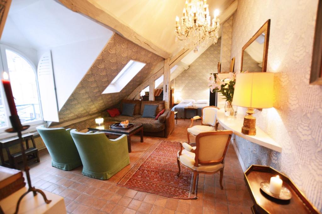 un salon avec un canapé, une table et des chaises dans l'établissement Charming Studio Near Louvre, à Paris
