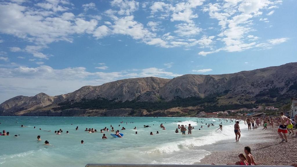 a group of people in the water at a beach at Apartmani Roko in Baška