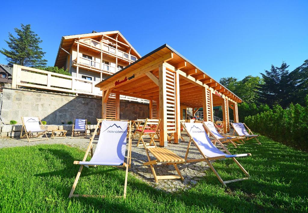 a group of deck chairs sitting in the grass at Dom Górski in Karpacz